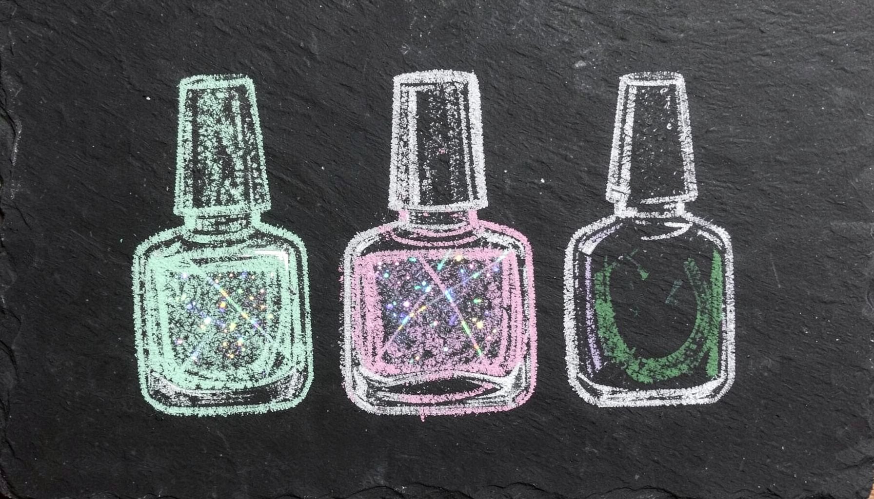 A chalk drawing on a dark slate board of three nail-polish bottles in varied shapes, one shimmering with holographic sparkle lines, rendered in soft mint green, lavender, and rose chalk on black slate.
